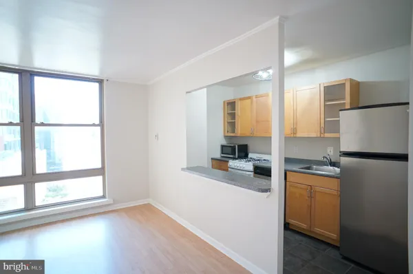a kitchen with a refrigerator a stove top oven and a large window