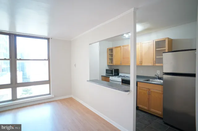 a kitchen with a refrigerator a stove top oven and a large window