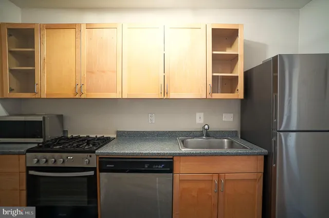 a kitchen with a sink a refrigerator and cabinets