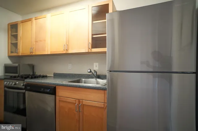 a kitchen with a sink a refrigerator and cabinets