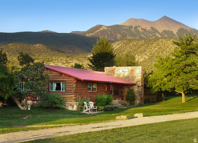 315 Abbey Road Moab, UT 84532 - Photo 2 of 46 View of front of home featuring a mountain view, a front yard, a metal roof, and a porch