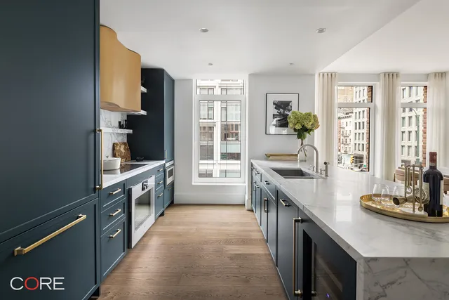 a large kitchen with stainless steel appliances a sink a stove and a refrigerator