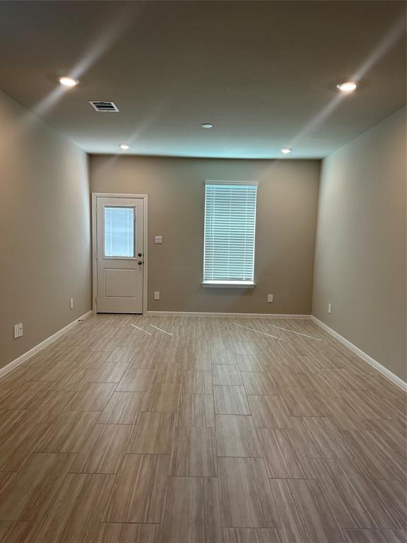 3008 Pecan Farm Lane Fort Worth, TX 76140 - Photo 2 of 10 an empty room with wooden floor and windows