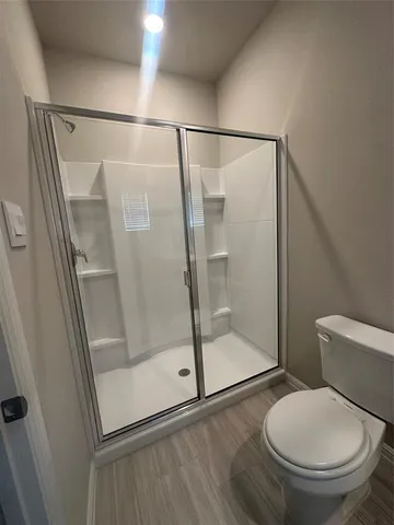 a bathroom with a toilet and a shower