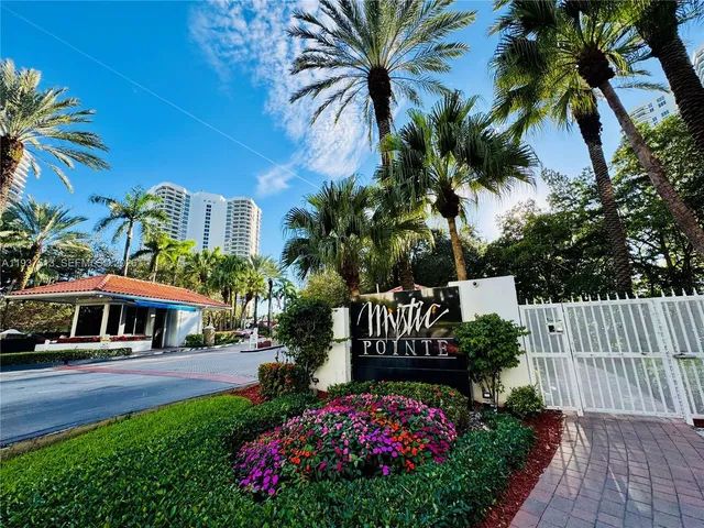 a front view of multi story residential apartment building with yard and green space