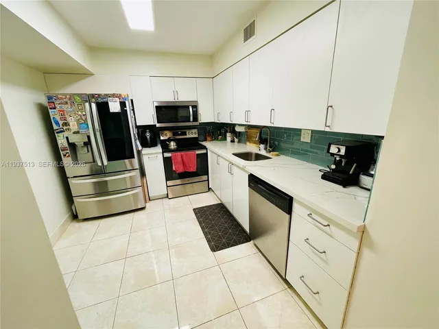a kitchen with stainless steel appliances a refrigerator sink and microwave