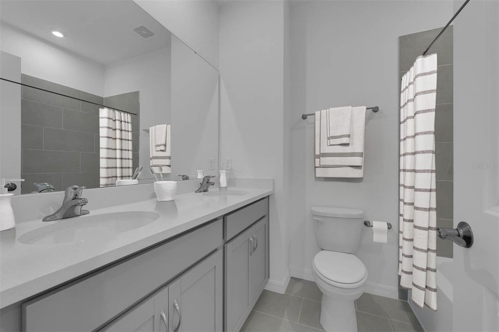 1812 Shadow Box Bend St. Cloud, FL 34771 - Photo 14 of 33 a bathroom with a toilet sink and mirror