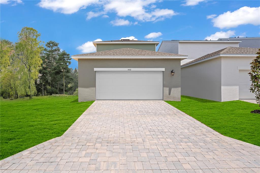 1812 Shadow Box Bend St. Cloud, FL 34771 - Photo 18 of 33 a view of a white house with a small yard and a large window