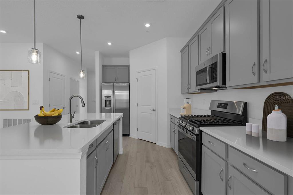 1812 Shadow Box Bend St. Cloud, FL 34771 - Photo 8 of 33 a kitchen with stainless steel appliances granite countertop a sink a stove and a refrigerator