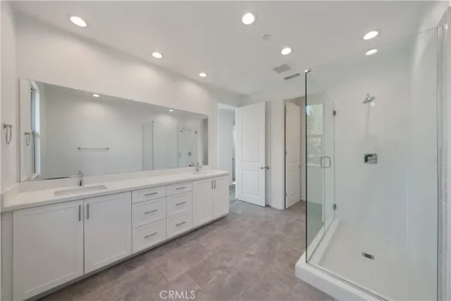 a bathroom with a shower sink and mirror