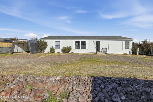 a view of a house with backyard and sitting area