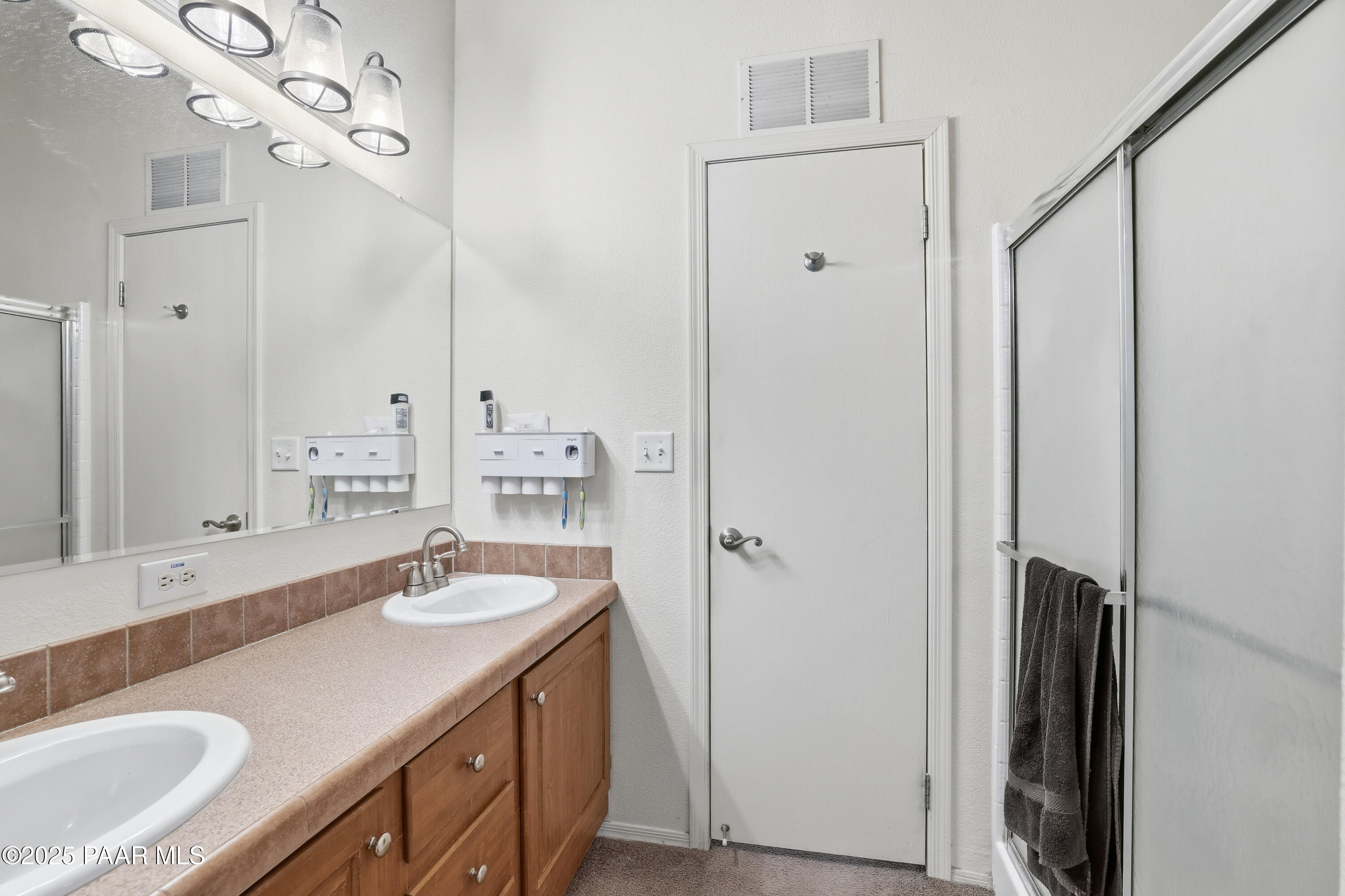 1810 Rhonda Road Chino Valley, AZ 86323 - Photo 15 of 29 a bathroom with a double vanity sink a mirror and a shower