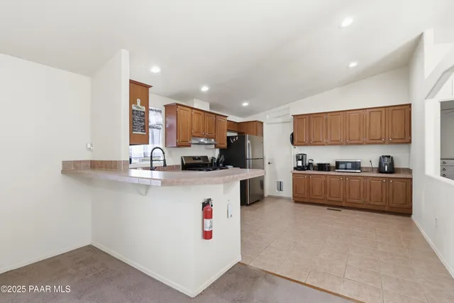 a kitchen with stainless steel appliances a refrigerator sink stove and microwave