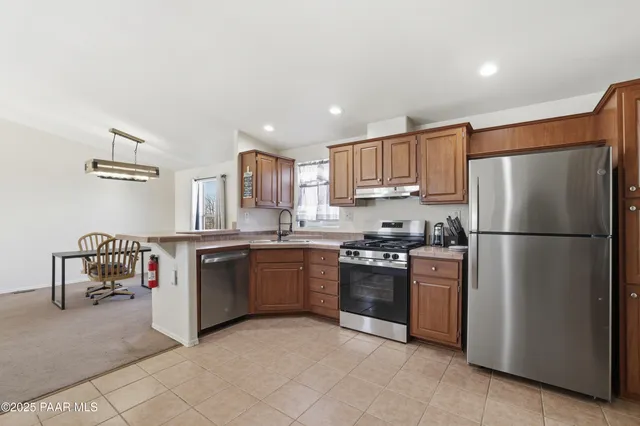 a kitchen with stainless steel appliances granite countertop a refrigerator sink and stove