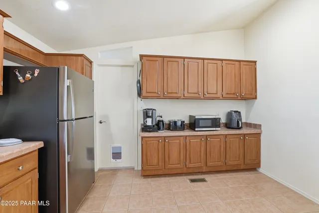 a kitchen with stainless steel appliances granite countertop a refrigerator and a stove top oven
