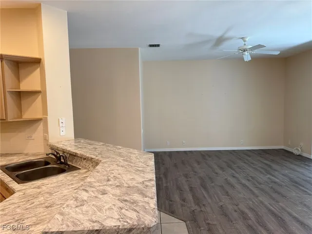 a open kitchen with a sink and dishwasher a refrigerator with a large mirror