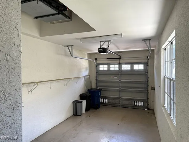 an empty room with wooden floor ceiling fan and windows