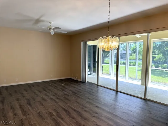 a view of an empty room with wooden floor and a fireplace