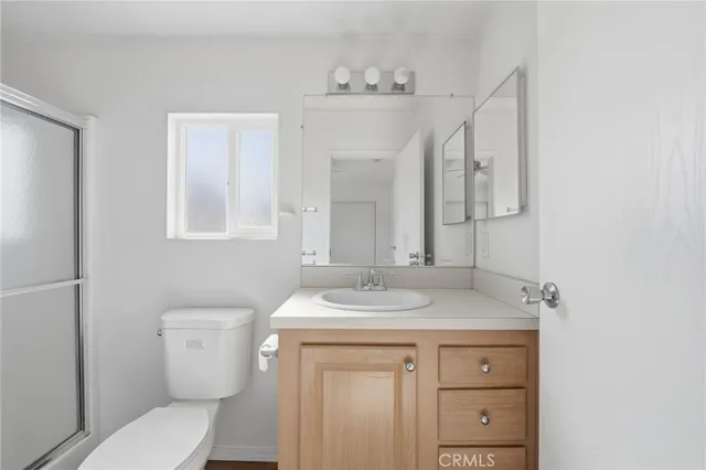 a bathroom with a granite countertop sink toilet a mirror and shower