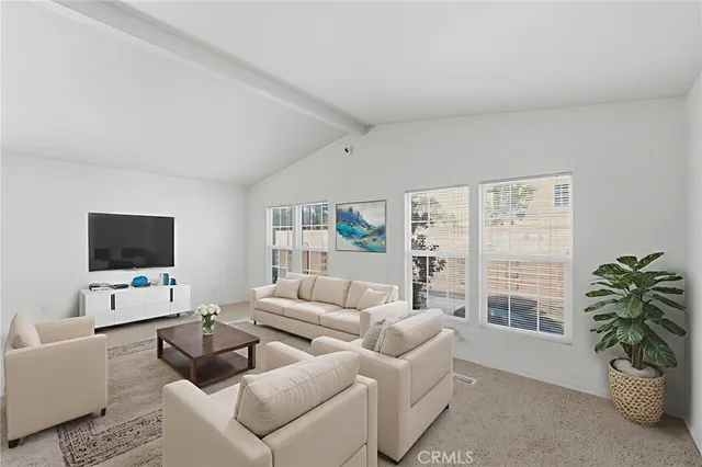 a living room with furniture a flat screen tv and a large window