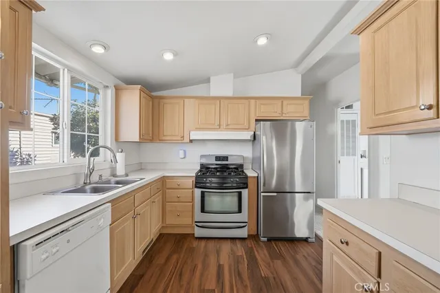 a kitchen with kitchen island granite countertop a sink stainless steel appliances and cabinets