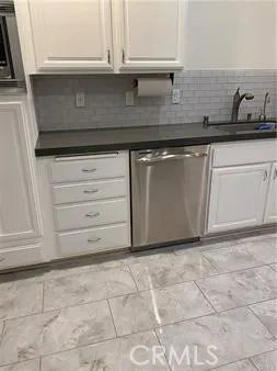 a kitchen with granite countertop white cabinets and white appliances