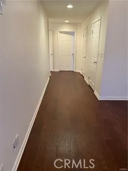 an empty room with wooden floor fireplace and windows