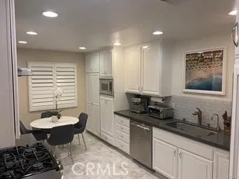 a kitchen with stainless steel appliances granite countertop a refrigerator a stove a sink dishwasher with a dining table and chairs