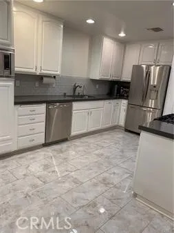 a kitchen with granite countertop a sink and cabinets