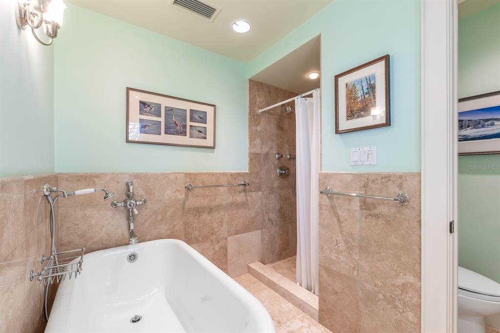 2571 Shore Lane Boca Grande, FL 33921 - Photo 20 of 38 a bathroom with a white bath tub a shower and a sink