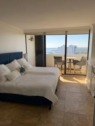 a bedroom with a bed and large window