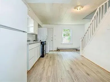 a view of a kitchen with wooden floor and electronic appliances