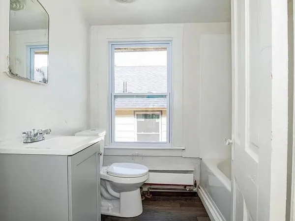 a bathroom with a sink toilet and window