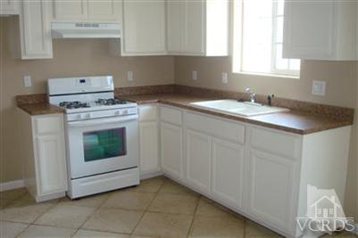 718 Teakwood Street Oxnard, CA 93033 - Photo 10 of 15 a kitchen with a stove top oven and cabinets