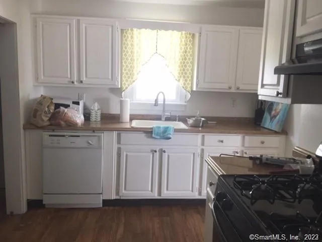 a kitchen with granite countertop white cabinets and a stove