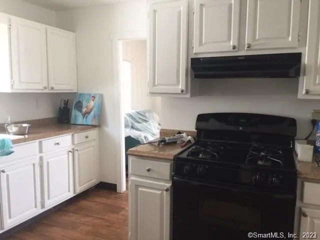 a kitchen with granite countertop white cabinets and black appliances