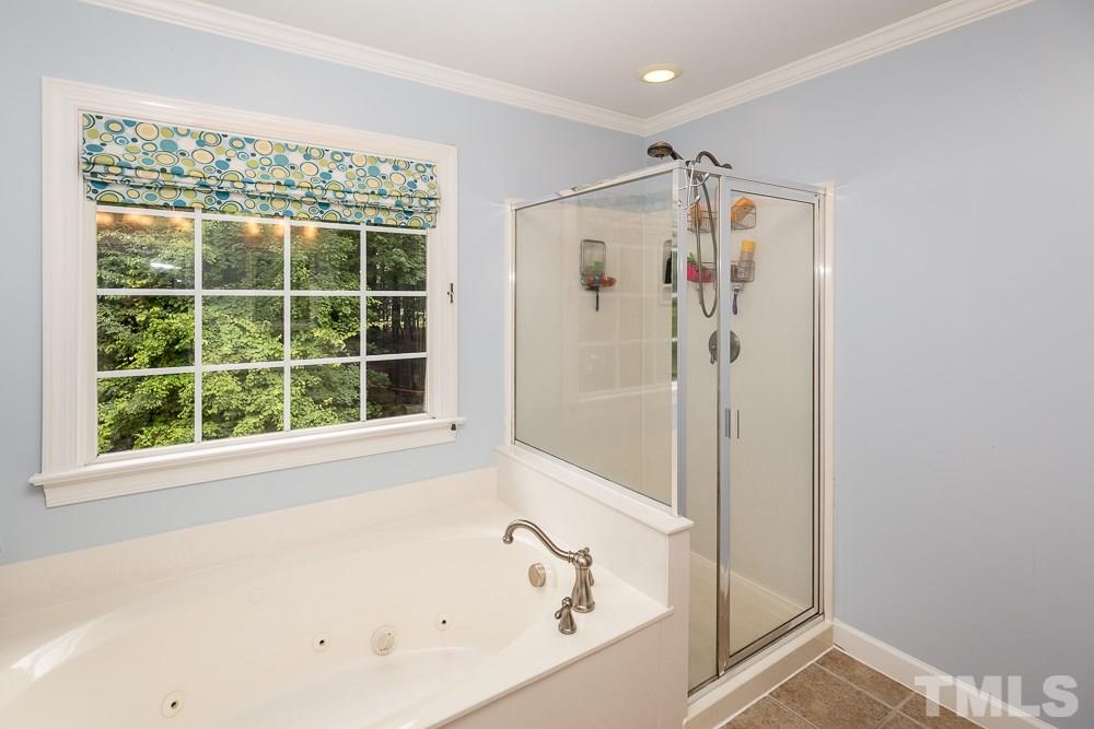 5016 Big Creek Road Raleigh, NC 27613 - Photo 14 of 25 a bathroom with a shower and a bathtub