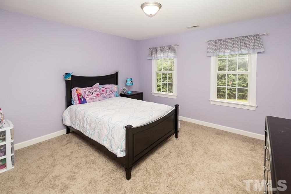 5016 Big Creek Road Raleigh, NC 27613 - Photo 18 of 25 a large bed sitting in a bedroom next to a window