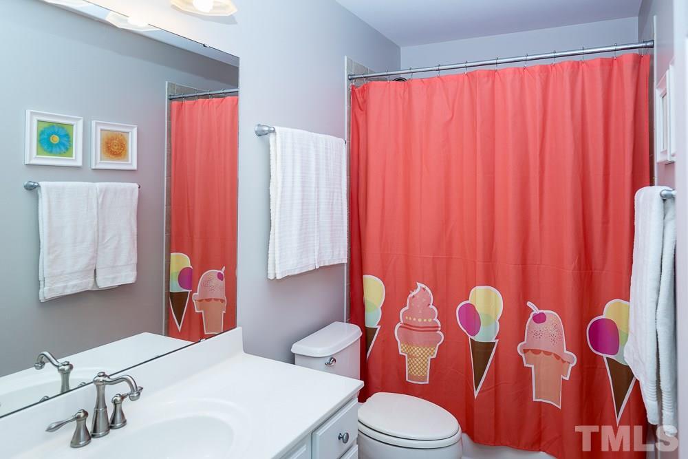 5016 Big Creek Road Raleigh, NC 27613 - Photo 20 of 25 a bathroom with a sink a toilet and shower curtain