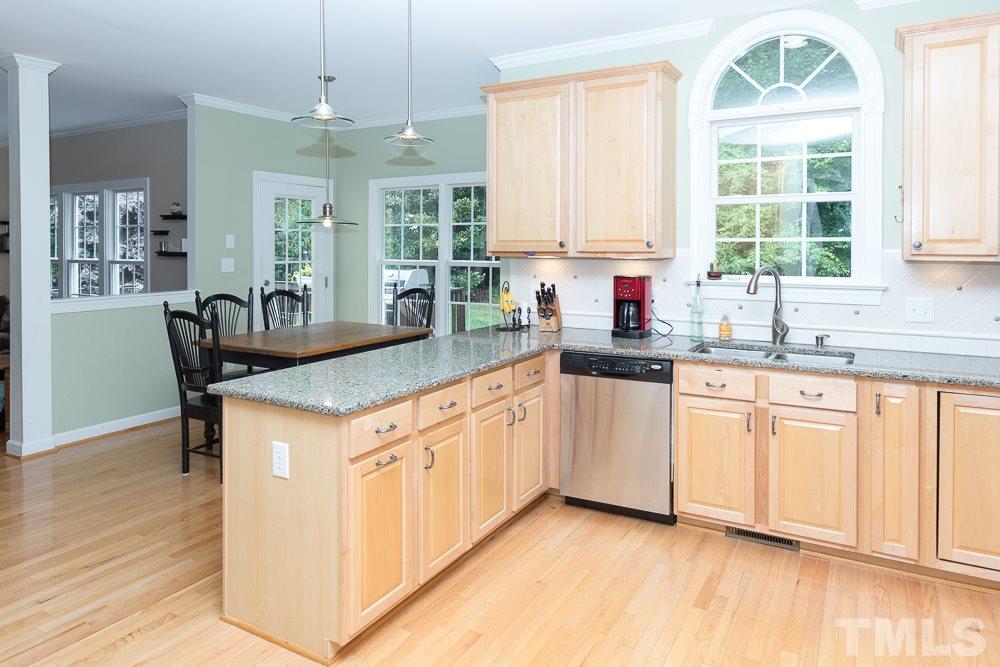 5016 Big Creek Road Raleigh, NC 27613 - Photo 7 of 25 a kitchen with granite countertop a sink cabinets a window and stainless steel appliances
