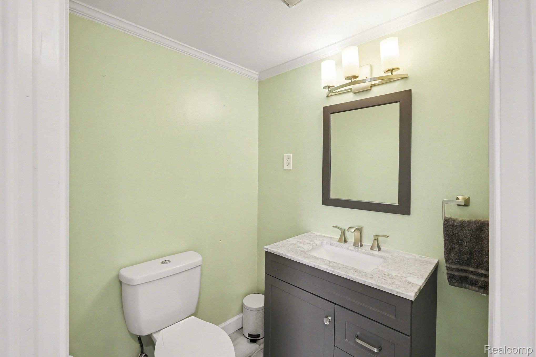 16485 Jennings Road Fenton, MI 48430 - Photo 18 of 27 Half bath with vanity and crown molding