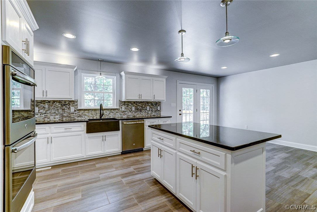 13521 Courthouse Road Dinwiddie, VA 23841 - Photo 18 of 35 a kitchen with stainless steel appliances granite countertop a sink counter space cabinets and a large window