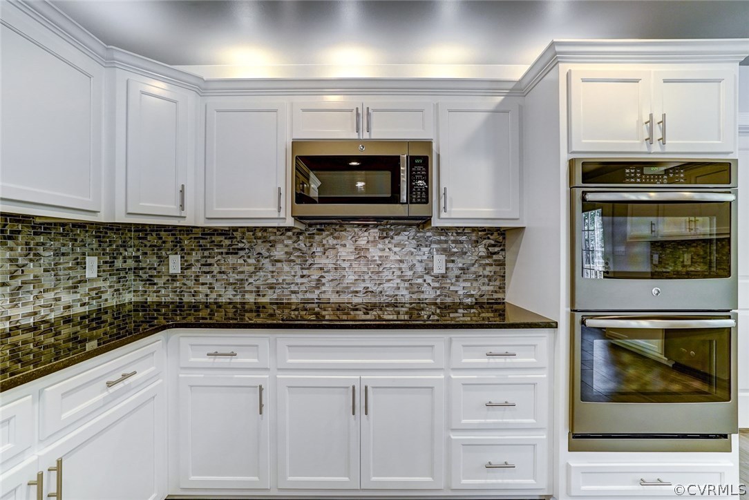 13521 Courthouse Road Dinwiddie, VA 23841 - Photo 19 of 35 a kitchen with white cabinets and stainless steel appliances