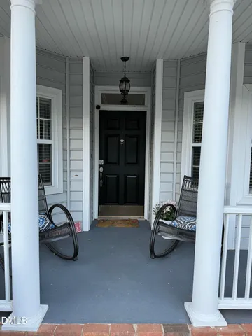 a view of a balcony with table and chairs and wooden floor