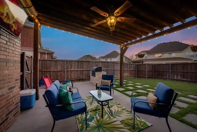 a view of a barn with big yard plants and large trees