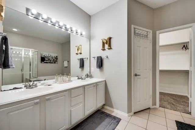a bathroom with a double vanity sink mirror and shower