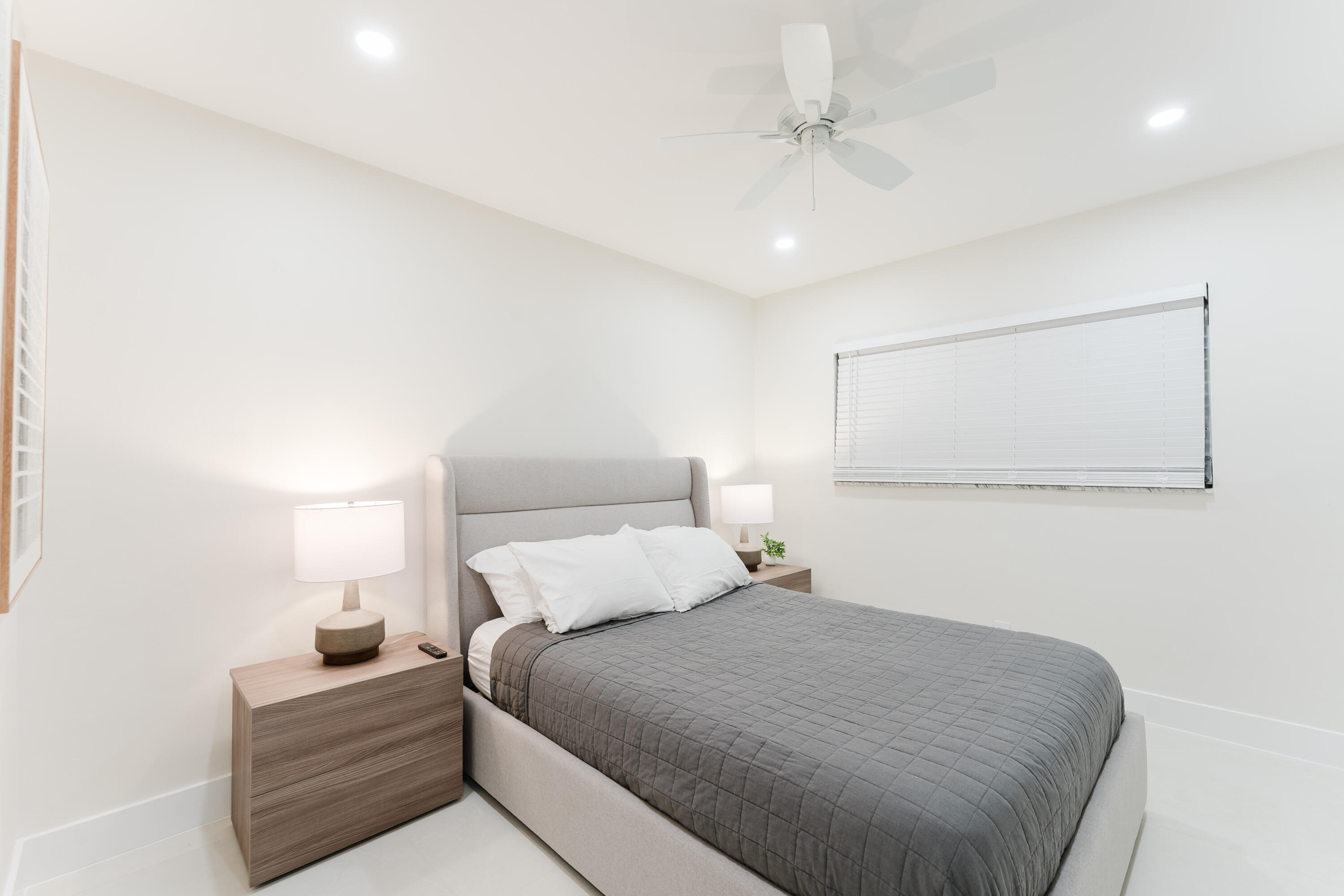 3199 Northeast 6th Drive Boca Raton, FL 33431 - Photo 33 of 49 a bedroom with a bed and lamp with the wall