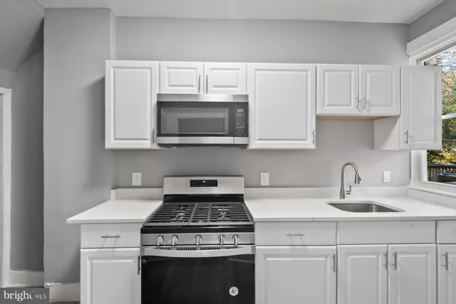 a kitchen with stainless steel appliances granite countertop white cabinets a sink and dishwasher