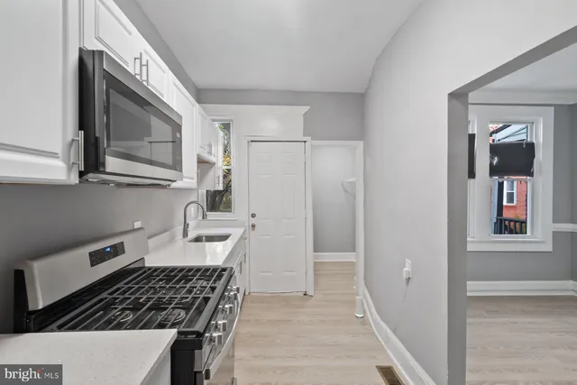 a kitchen with a sink a stove and cabinets