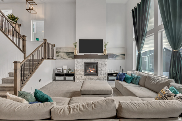 1577 Quailhill Road Saratoga Springs, UT 84045 - Photo 10 of 46 Living room featuring a high ceiling, carpet flooring, and a stone fireplace